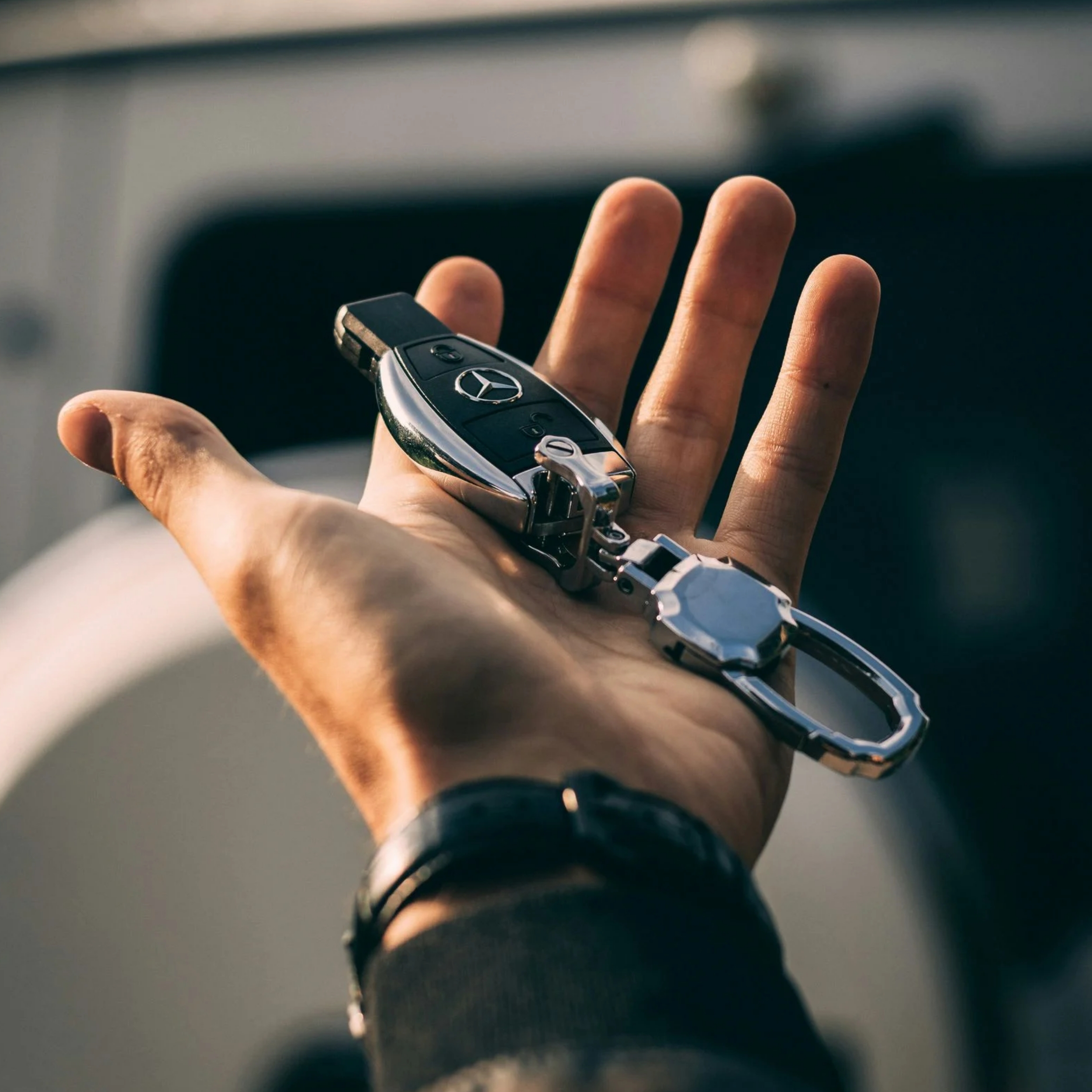 male hand holding mercedes car key