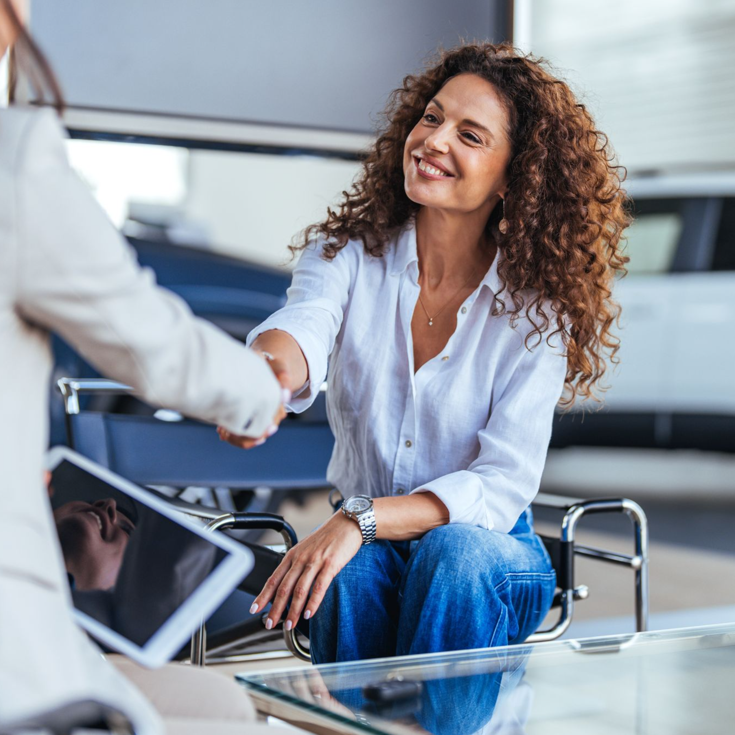 woman shaking hands smiling after taking out a new car on finance 1:1