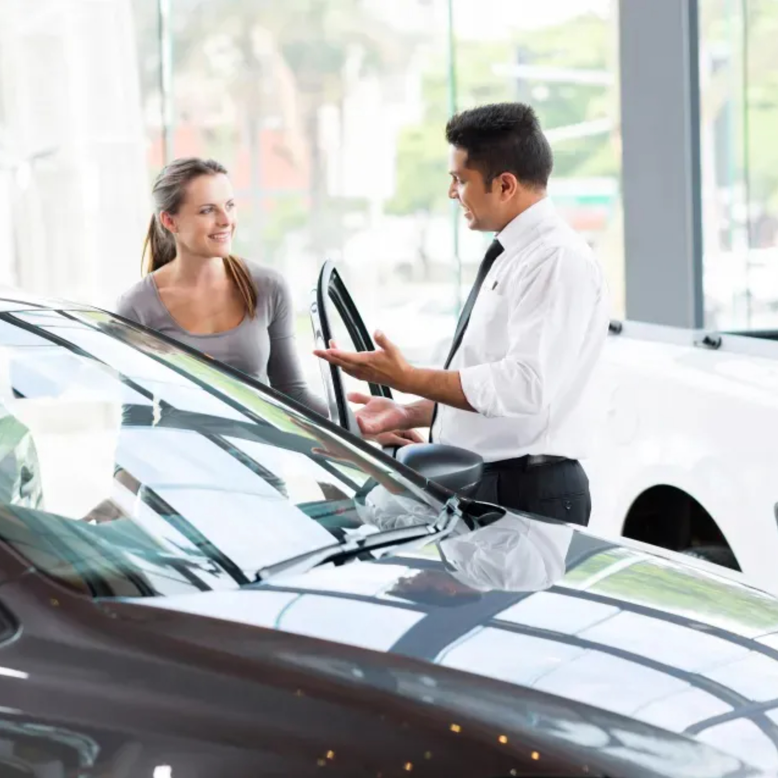 Man car dealer helping woman choose car and finance in showroom - fca redress scheme
